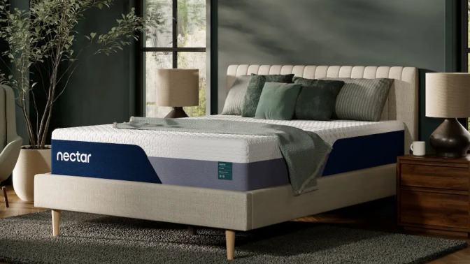 A Nectar Premier Copper mattress on a bed frame with a white headboard. The mattress has a white and gray cover with the Nectar logo.